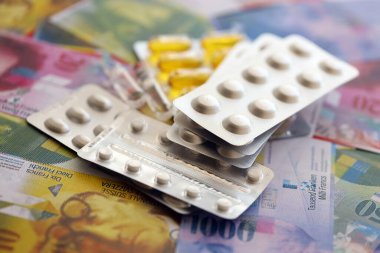 İsviçre frangı ve ilaç hapları. Mevcut para ve uyuşturucu banknotları büyük miktarda masada yatıyor. İsviçre 'de ilaç ve eczane kavramı