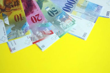 Sarıya İsviçre frangı banknotları. Mevcut frank para faturaları büyük miktarda masada yatıyor. İsviçre 'de iş ve yatırım kavramı