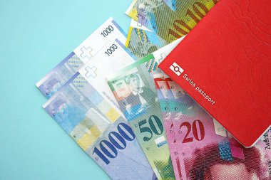 İsviçre frangı banknotları ve mavi üzerine pasaport. Mevcut para banknotları mavi üzerine kuruludur. İsviçre 'de iş ve yatırım kavramı