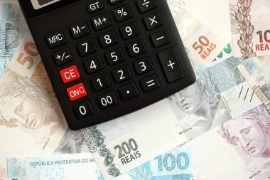 Brezilya banknotları ve hesap makinesi. Mevcut Brezilya gerçek para ve hesap makinesi büyük miktarda masada yatıyor. Brezilya 'da vergilendirme ve para konsepti