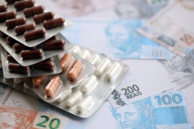 Brezilya bankaları ve ilaç hapları. Mevcut Brezilya gerçek para ve uyuşturucu banknotları büyük miktarda masada yatıyor. Brezilya 'da ilaç ve eczane kavramı