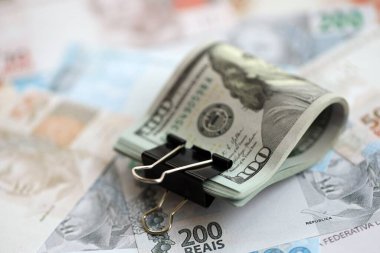 Bir sürü Amerikan doları büyük miktarda Brezilya banknotunun üzerinde yatar. Amerika 'nın parası Brezilya' nın para akışına bağlı. Brezilya 'da ekonomi ve döviz kuru kavramı