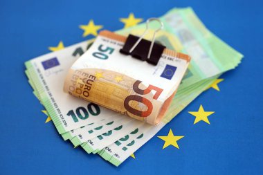 Avrupa sendikasının mavi bayrağına bir deste avroluk banknot yakın. Avrupa 'da iş ve ekonomi kavramı