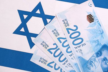 Israel New Shekels banknotları ulusal bayrak üzerinde. İsrail 'in şu anki para faturaları büyük oranda bayrağın üzerinde yatıyor. İsrail 'de iş ve yatırım kavramı