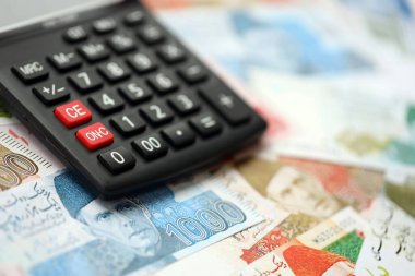 Pakistan banknotları ve hesap makinesi. Pakistan 'ın mevcut para ve hesap makinesi büyük miktarda masada yatıyor. Pakistan 'da vergi ve para sayımı kavramı