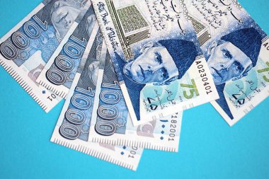 Pakistan banknotları mavi arka planda. Pakistan 'ın mevcut para faturaları büyük miktarda masada yatıyor. Pakistan 'da iş ve yatırım kavramı