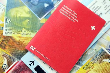 İsviçre frangı banknotları ve biletli pasaport. Mevcut banknotlar ve biyometrik geçiş kartları büyük miktarda masada yatıyor. İsviçre 'de seyahat ve tatil kavramı