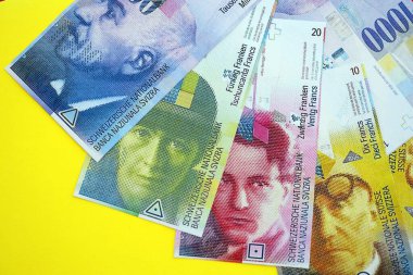 Sarıya İsviçre frangı banknotları. Mevcut frank para faturaları büyük miktarda masada yatıyor. İsviçre 'de iş ve yatırım kavramı