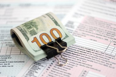 Masada 1040 bireysel gelir vergisi iadesi formuyla birlikte büyük miktarda Amerikan dolarları var. ABD 'de vergilendirme ve muhasebe kavramı