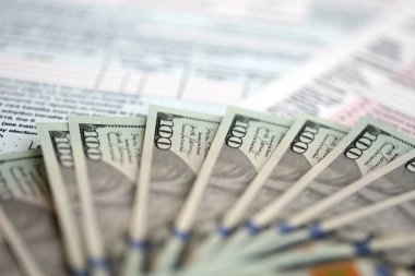 Masada 1040 bireysel gelir vergisi iadesi formuyla birlikte büyük miktarda Amerikan doları banknotları var. ABD 'de vergilendirme ve muhasebe kavramı