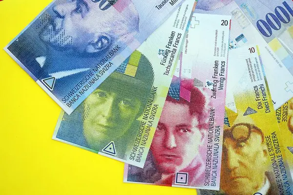 Sarıya İsviçre frangı banknotları. Mevcut frank para faturaları büyük miktarda masada yatıyor. İsviçre 'de iş ve yatırım kavramı