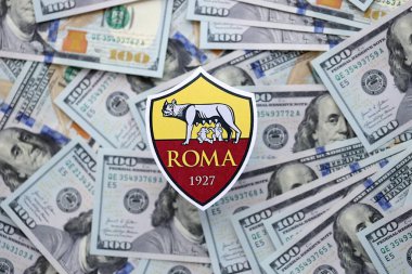 KYIV, UKRAINE - 23 Şubat 2025 Roma futbol kulübü rozeti yüzlük banknotların üzerinde yatıyor