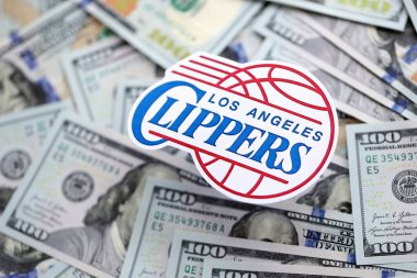 KYIV, UKRAINE - 23 Şubat 2025 Los Angeles Clippers basketbol takımı rozeti yüzlük banknotların üzerinde.