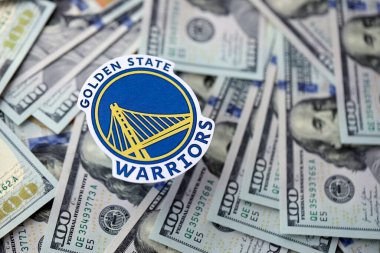 KYIV, UKRAINE - 23 Şubat 2025 Golden State Warriors basketbol takımı rozeti yüzlük banknotların üzerinde.