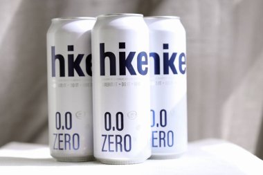 KYIV, UKRAINE - 19 Nisan 2025 Alüminyum kutularda sıfır alkolsüz bira. Bira markası logosunu kapatıyoruz.