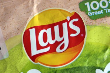 KYIV, UKRAINE - 19 Nisan 2025 Fırında fırında yoğurt ve yeşil patates cipsi ve Lays resmi logosu.