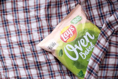 KYIV, UKRAINE - 19 Nisan 2025 Fırında fırında yoğurt ve yeşil patates cipsi ve Lays resmi logosu.