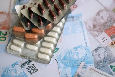 Brezilya bankaları ve ilaç hapları. Mevcut Brezilya gerçek para ve uyuşturucu banknotları büyük miktarda masada yatıyor. Brezilya 'da ilaç ve eczane kavramı