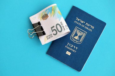 Israel New Shekels banknotları ve mavi arka planda pasaport. İsrail 'in şu anki para banknotları büyük oranda mavi üzerine yatar. İsrail 'de finans ve nakit kavramı