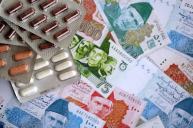 Pakistan banknotları ve ilaç hapları. Pakistan 'ın mevcut para ve uyuşturucu faturaları büyük miktarda masada yatıyor. Pakistan 'da ilaç ve eczane kavramı