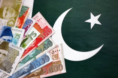 Pakistan 'ın bayrak geçmişi üzerine Pakistan banknotları. Pakistan 'ın mevcut para faturaları büyük miktarlarda pankartta yatıyor. Pakistan 'da ekonomi ve ticaret kavramı