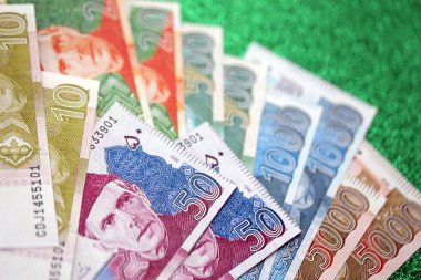 Pakistan parlayan yeşil arka planda banknotlar halinde. Pakistan 'ın mevcut para faturaları büyük miktarda masada yatıyor. Pakistan 'da iş ve yatırım kavramı