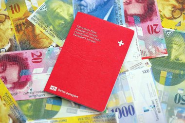 İsviçre frangı banknotları ve pasaportu. Mevcut banknotlar ve biyometrik geçiş kartları büyük miktarda masada yatıyor. İsviçre 'de seyahat ve tatil kavramı
