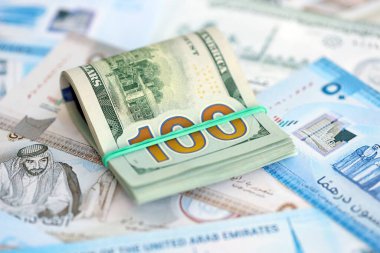 Birleşik Arap Emirlikleri kara para birimi faturaları ve biz dolar banknotları yakın yakın. Ekonomi ve döviz kuru kavramı