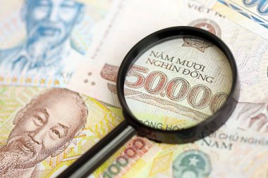 Vietnam dong para birimi faturaları ve büyüteç yakın çekim. Finansal izleme ve vergilendirme kavramı