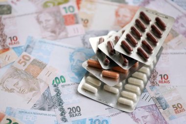 Brezilya bankaları ve ilaç hapları. Mevcut Brezilya gerçek para ve uyuşturucu banknotları büyük miktarda masada yatıyor. Brezilya 'da ilaç ve eczane kavramı