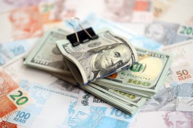 Bir sürü Amerikan doları büyük miktarda Brezilya banknotunun üzerinde yatar. Amerika 'nın parası Brezilya' nın para akışına bağlı. Brezilya 'da ekonomi ve döviz kuru kavramı