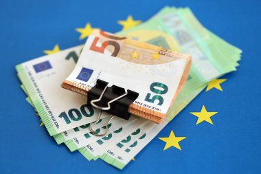 Avrupa sendikasının mavi bayrağına bir deste avroluk banknot yakın. Avrupa 'da iş ve ekonomi kavramı