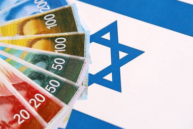 Israel New Shekels banknotları ulusal bayrak üzerinde. İsrail 'in şu anki para faturaları büyük oranda bayrağın üzerinde yatıyor. İsrail 'de iş ve yatırım kavramı