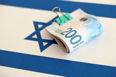 Israel New Shekels banknotları ulusal bayrak üzerinde. İsrail 'in şu anki para faturaları büyük oranda bayrağın üzerinde yatıyor. İsrail 'de iş ve yatırım kavramı