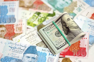 Bir sürü Amerikan doları Pakistan Rupileri 'nin banknotlarına yakın duruyor. Amerikan para demeti Pakistan 'ın para banknotlarında yatıyor. Pakistan 'da ekonomi ve döviz kuru kavramı