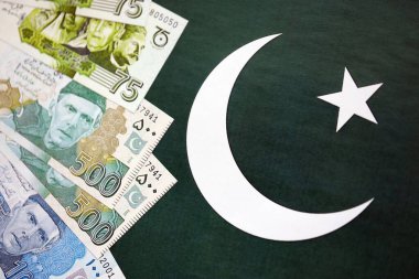 Pakistan 'ın bayrak geçmişi üzerine Pakistan banknotları. Pakistan 'ın mevcut para faturaları büyük miktarlarda pankartta yatıyor. Pakistan 'da ekonomi ve ticaret kavramı