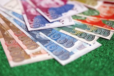 Pakistan parlayan yeşil arka planda banknotlar halinde. Pakistan 'ın mevcut para faturaları büyük miktarda masada yatıyor. Pakistan 'da iş ve yatırım kavramı