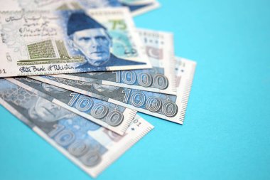 Pakistan banknotları mavi arka planda. Pakistan 'ın mevcut para faturaları büyük miktarda masada yatıyor. Pakistan 'da iş ve yatırım kavramı