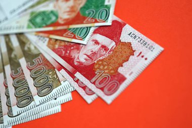 Pakistan kırmızı arka planda banknotlar halinde. Pakistan 'ın mevcut para faturaları büyük miktarda masada yatıyor. Pakistan 'da iş ve yatırım kavramı
