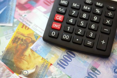 İsviçre frangı banknotları ve hesap makinesi. Mevcut frank para faturaları ve calc büyük miktarda masada yatıyor. İsviçre 'de vergilendirme ve para konsepti