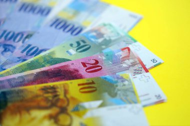 Sarıya İsviçre frangı banknotları. Mevcut frank para faturaları büyük miktarda masada yatıyor. İsviçre 'de iş ve yatırım kavramı