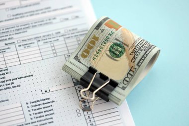 Masada 1040 bireysel gelir vergisi iadesi formuyla birlikte büyük miktarda Amerikan dolarları var. ABD 'de vergilendirme ve muhasebe kavramı