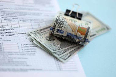Masada 1040 bireysel gelir vergisi iadesi formuyla birlikte büyük miktarda Amerikan doları banknotları var. ABD 'de vergilendirme ve muhasebe kavramı