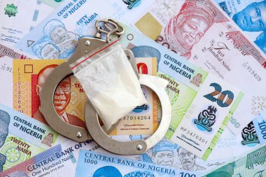 Nijerya naira para birimi faturaları ve kelepçeli kokain paketi. Uyuşturucu suçları kavramı