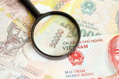 Vietnam dong para birimi faturaları ve büyüteç yakın çekim. Finansal izleme ve vergilendirme kavramı
