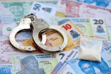 Nijerya naira para birimi faturaları ve kelepçeli kokain paketi. Uyuşturucu suçları kavramı