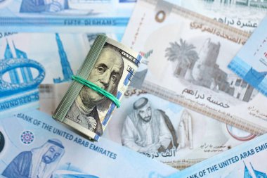 Birleşik Arap Emirlikleri kara para birimi faturaları ve biz dolar banknotları yakın yakın. Ekonomi ve döviz kuru kavramı