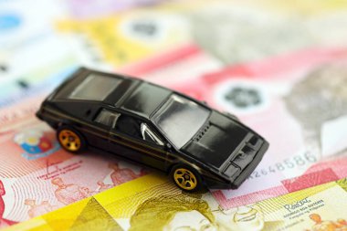 Filipinler Peso para birimi faturaları ve oyuncak araba. Araba sahibi olma kavramı.