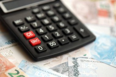 Brezilya banknotları ve hesap makinesi. Mevcut Brezilya gerçek para ve hesap makinesi büyük miktarda masada yatıyor. Brezilya 'da vergilendirme ve para konsepti