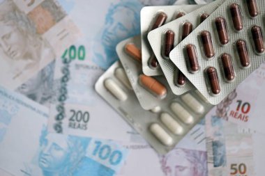 Brezilya bankaları ve ilaç hapları. Mevcut Brezilya gerçek para ve uyuşturucu banknotları büyük miktarda masada yatıyor. Brezilya 'da ilaç ve eczane kavramı